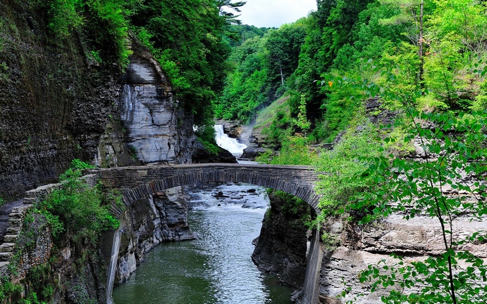 Stone bridge over a gorge with a waterfall