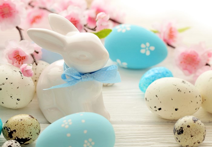 Easter bunny with decorated eggs and pink flowers