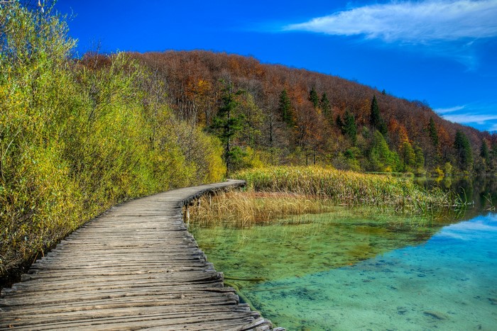 Wooden boardwalk along a clear lake in Plitvice, Croatia
