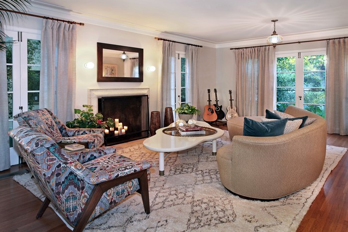 Living room with fireplace, armchairs, and guitars