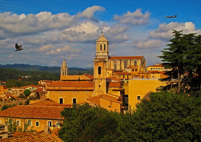 Girona, Spain cityscape with cathedral and flying airplane