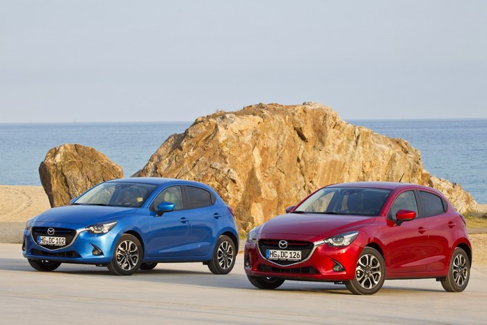 Two Mazda 2 cars on a beach