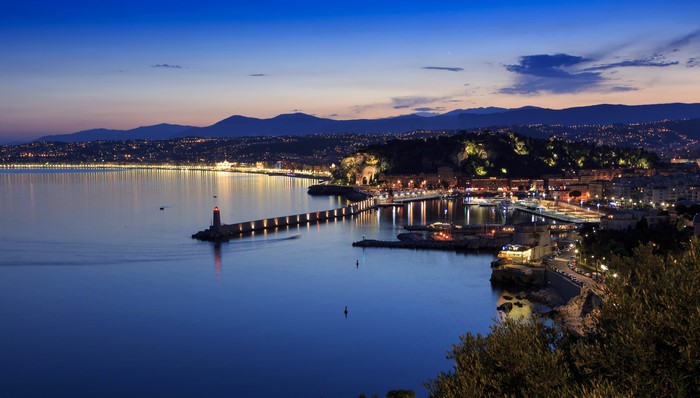 Night view of Nice, France coastline with lighthouse