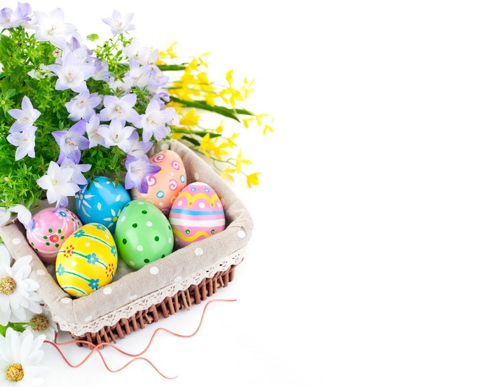 Easter eggs in a wicker basket with flowers