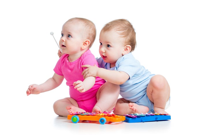 Two infants playing with toys
