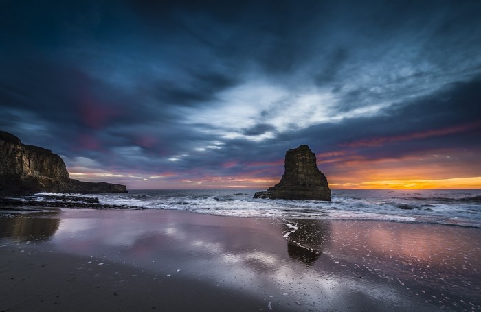 Dramatic sunset over a rocky coast with sea stacks