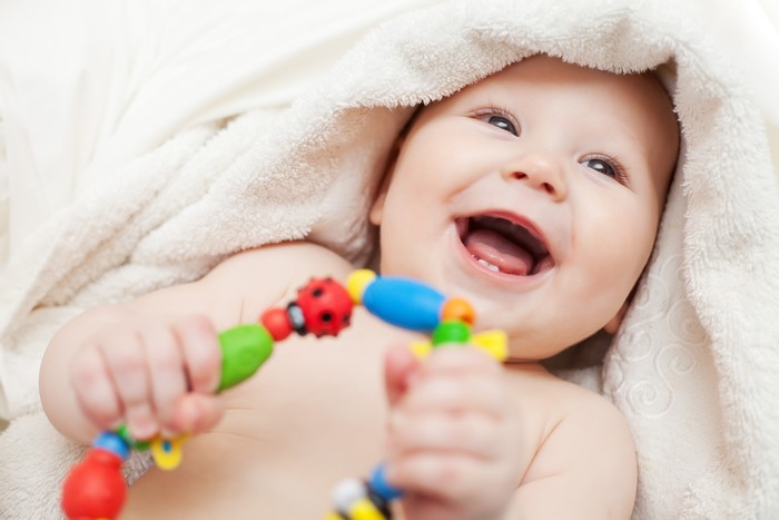 Baby smiling with a toy
