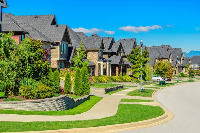 Suburban street with modern houses and manicured lawns