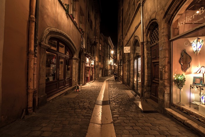 Cobblestone alley in Lyon, France at night