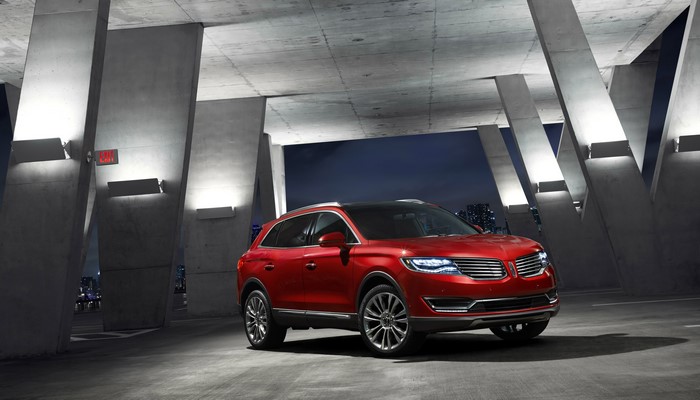 Red Lincoln MKX parked under concrete structure at night
