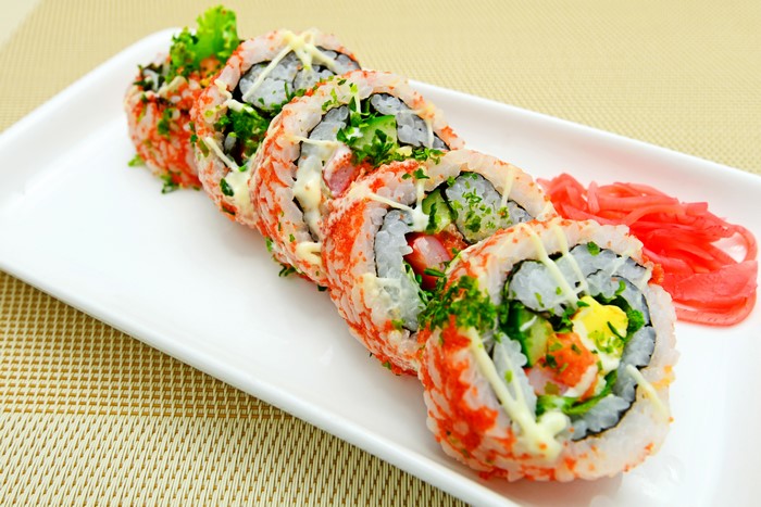 Sushi rolls with pickled ginger on a white plate