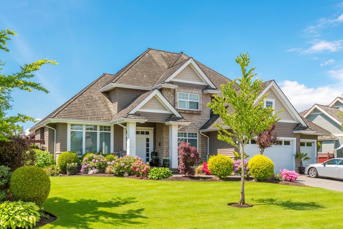 Luxury house with manicured lawn and trees