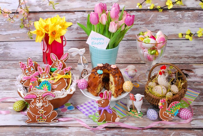 Easter table with tulips, daffodils, cookies, cake, and eggs