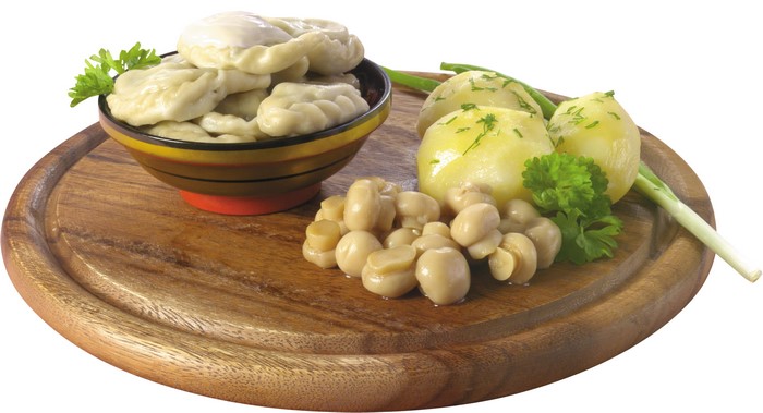 Pelmeni with potatoes, mushrooms, and herbs on a wooden board
