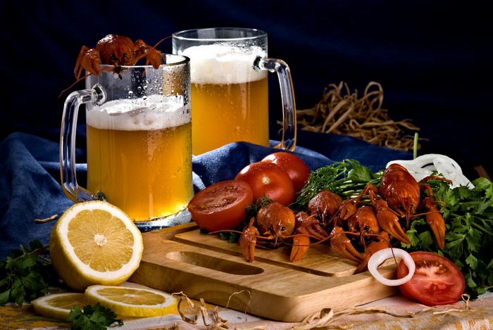 Beer, Crayfish, Tomatoes, and Lemons on a Table