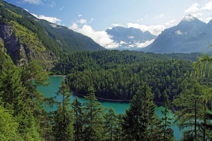Turquoise lake surrounded by forests and mountains in Tirol, Austria