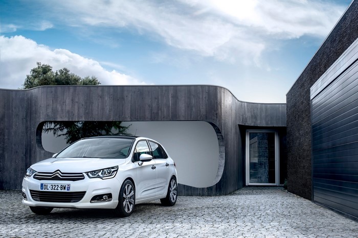 White Citroen C4 parked in front of a modern house