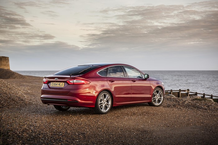 Red Ford Mondeo parked on a beach by the sea