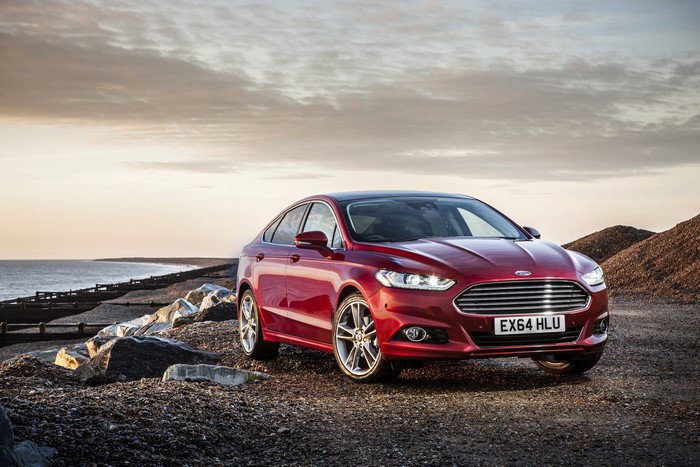 Red Ford Mondeo parked on a rocky beach