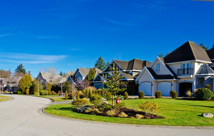 Suburban street with modern houses and green lawns