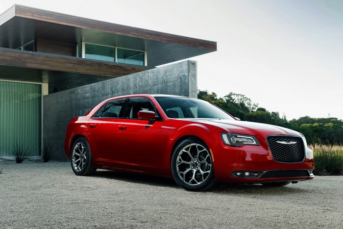 Red Chrysler 300 S parked in front of a modern house