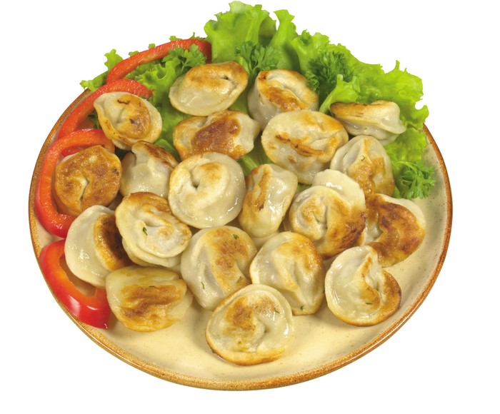 Pelmeni on a plate with lettuce and red pepper