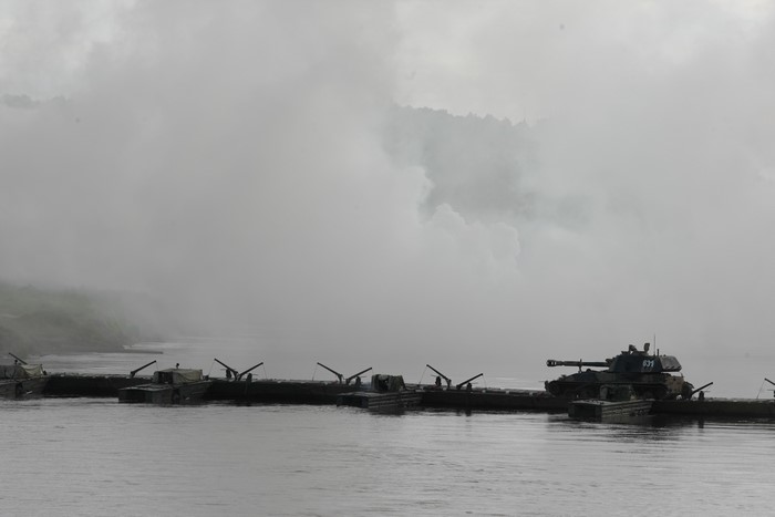 Tanks on a pontoon bridge in fog