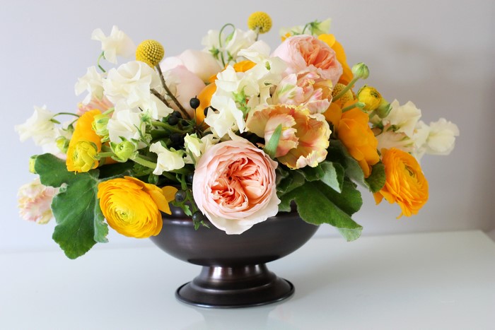 Floral arrangement with roses, ranunculus, and tulips in a vase