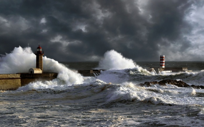 Two lighthouses during a storm with large waves