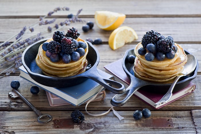 Pancakes with blueberries and blackberries in cast iron pans