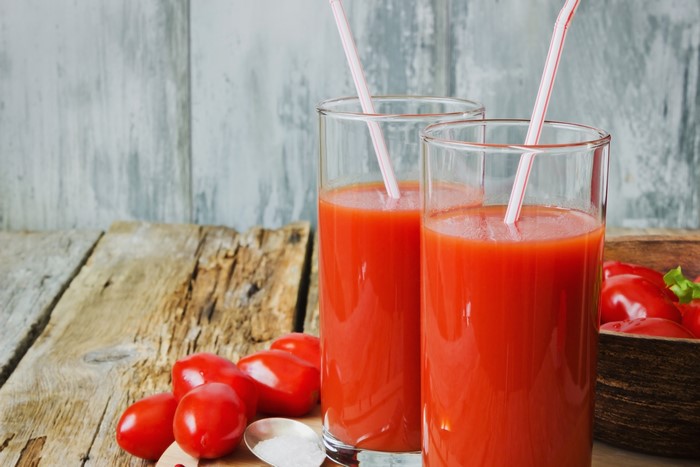 Two glasses of tomato juice with tomatoes and salt