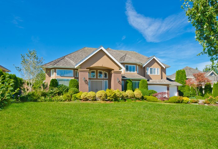 Large suburban house with manicured lawn and landscaping