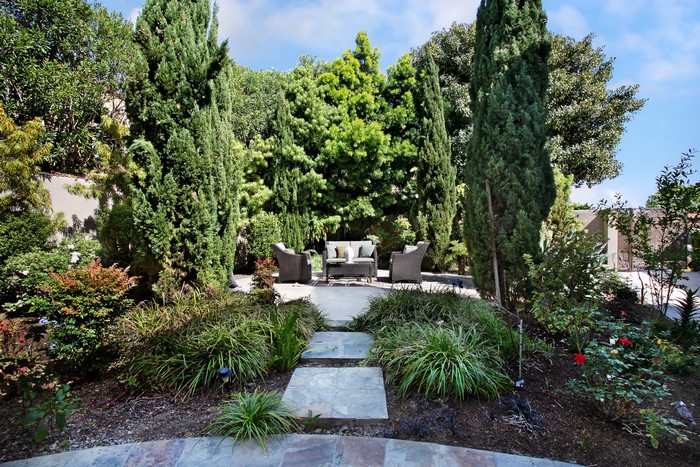 Outdoor seating area surrounded by trees and shrubs