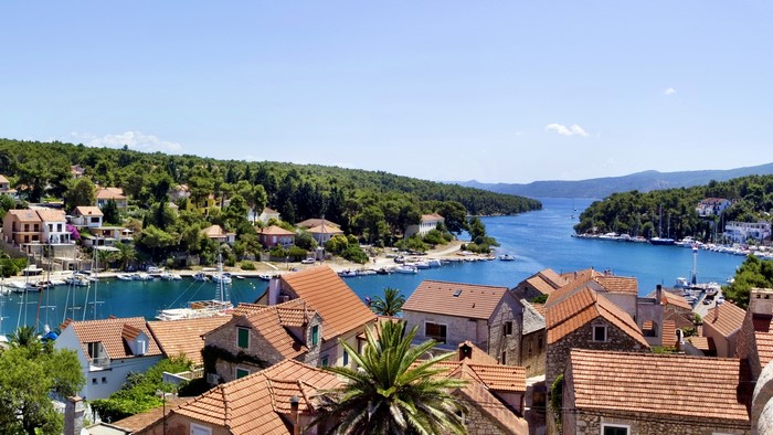 Coastal village with red-tiled roofs and boats in Croatia