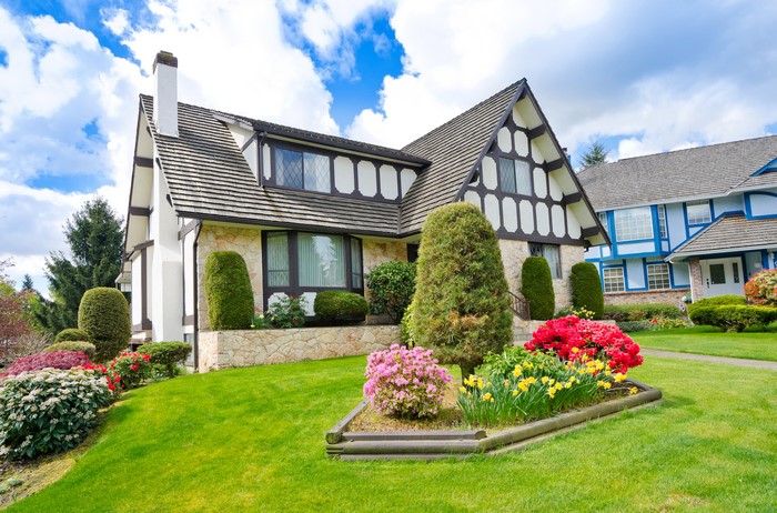 Tudor-style house with manicured lawn and flowers