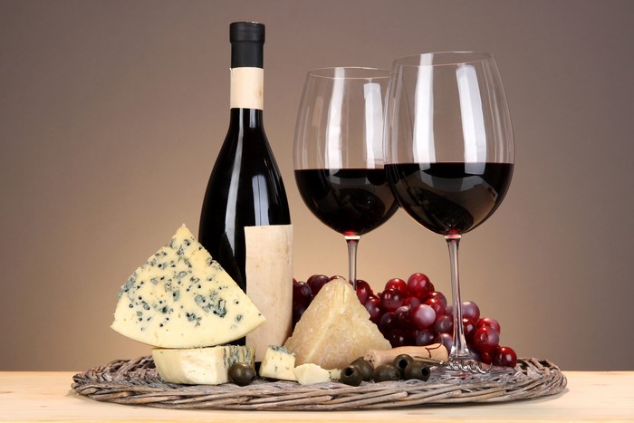 Wine bottle, glasses, cheese, and grapes