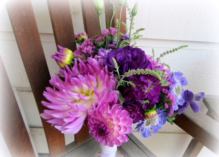 Purple and pink dahlia bouquet on a wooden chair