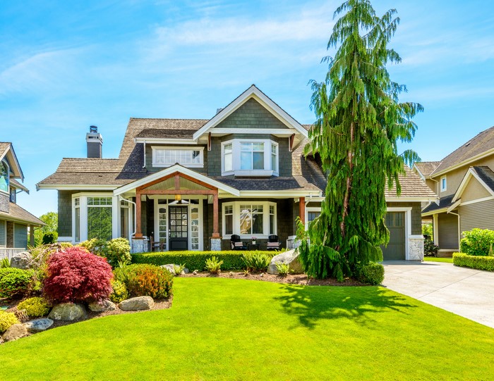 Green house with manicured lawn and landscaping