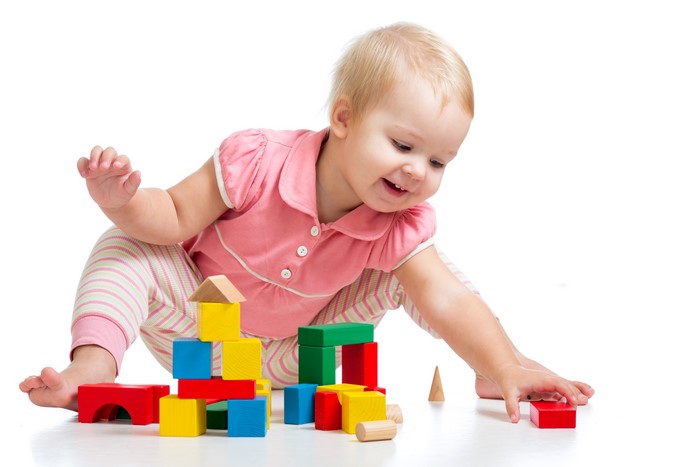 Infant girl playing with colorful blocks