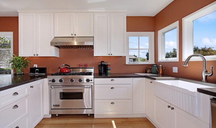 Modern Kitchen with White Cabinets and Orange Walls