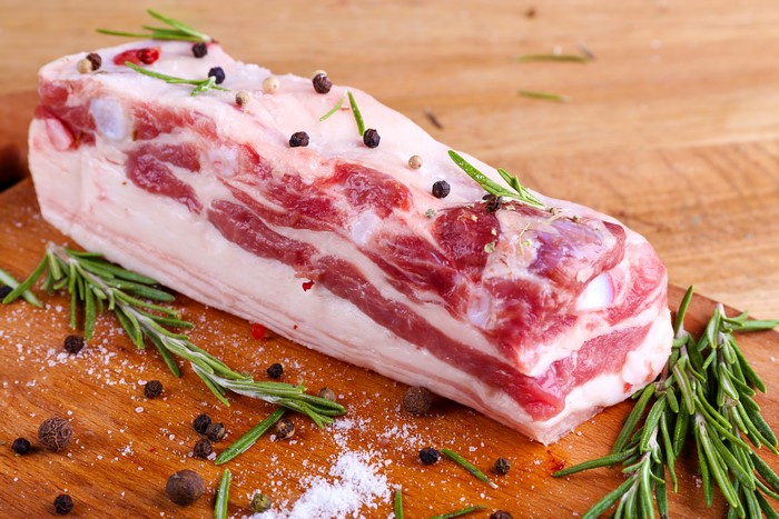 Raw pork belly with rosemary and peppercorns