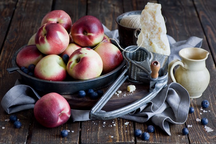 Nectarines and blueberries with cheese grater and jug