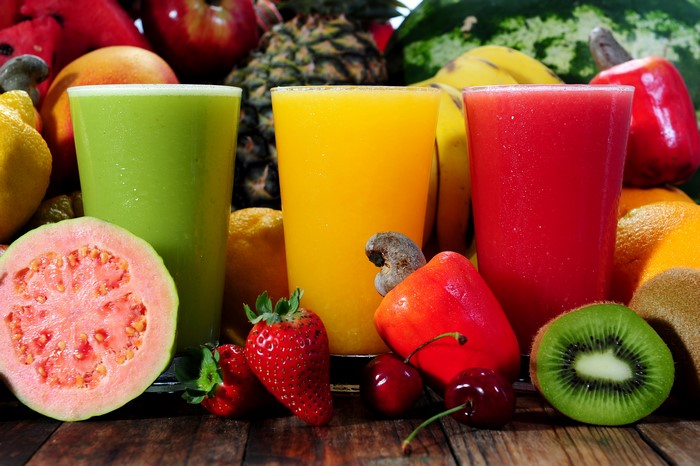 Three glasses of juice with fruits