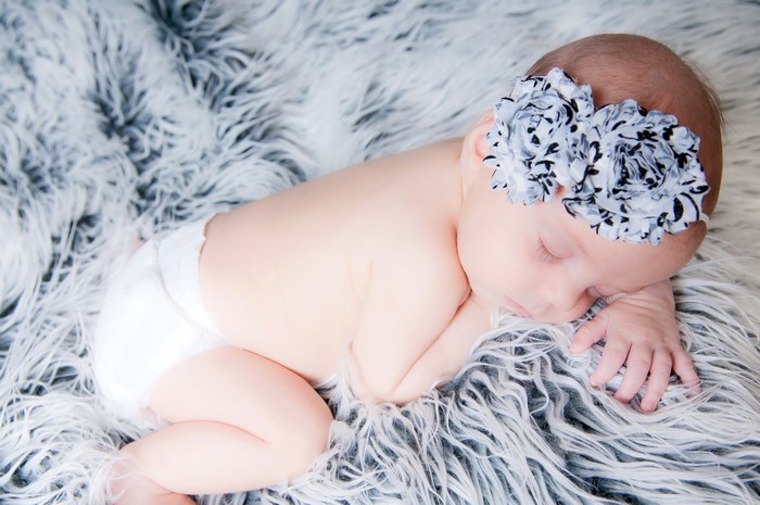 Newborn baby sleeping on fluffy blanket