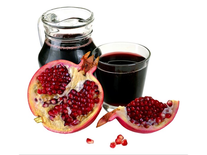Pomegranate juice in a glass and jug with fruit