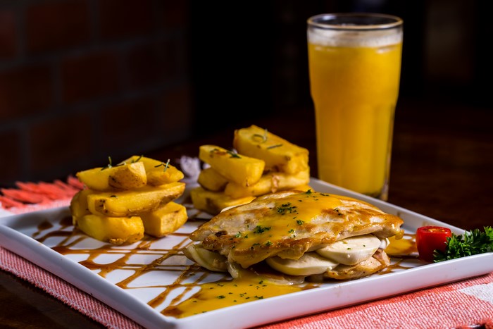 Chicken dish with fries and orange juice