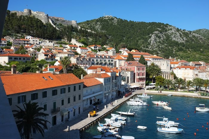 Town and harbor with boats and castle on hill