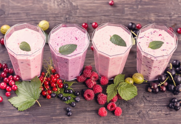 Four berry smoothies with fresh berries