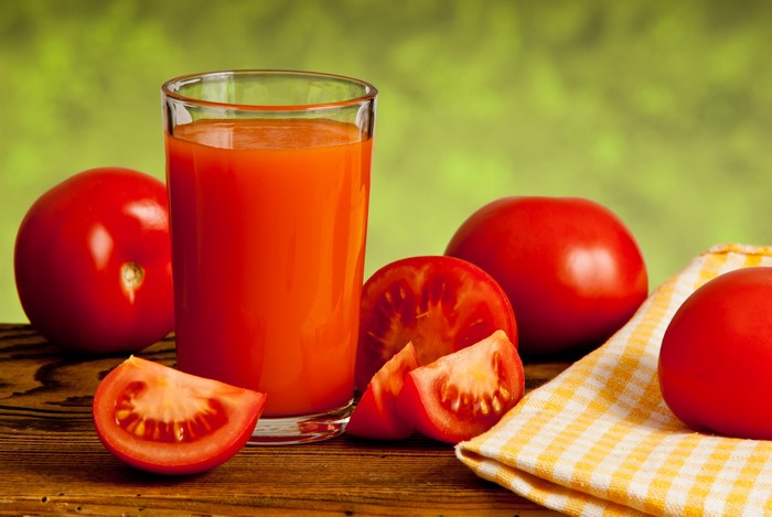 Tomato juice in a glass with tomatoes