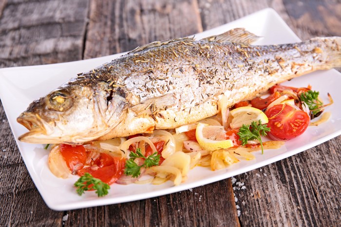 Whole roasted fish with tomatoes and lemon